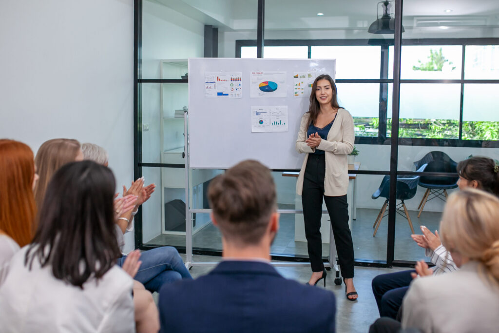 A professional woman presenting to her team, outlining personalized marketing strategies.