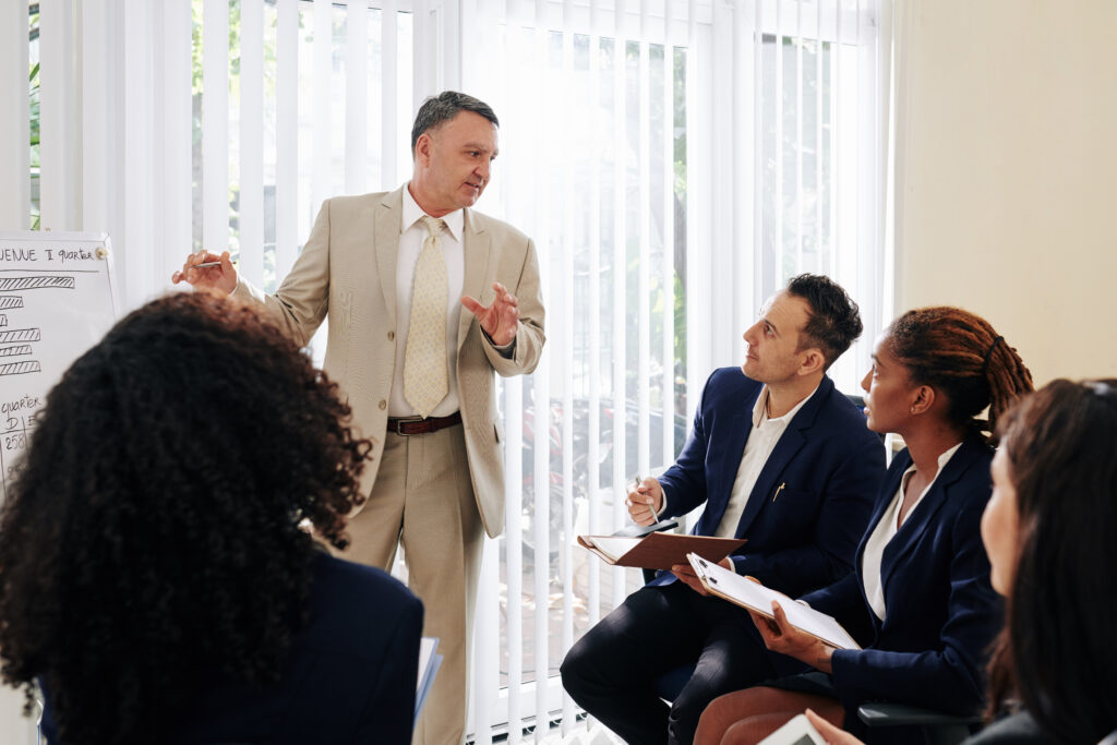An executive guiding a focused team discussion during an interactive leadership coaching session.