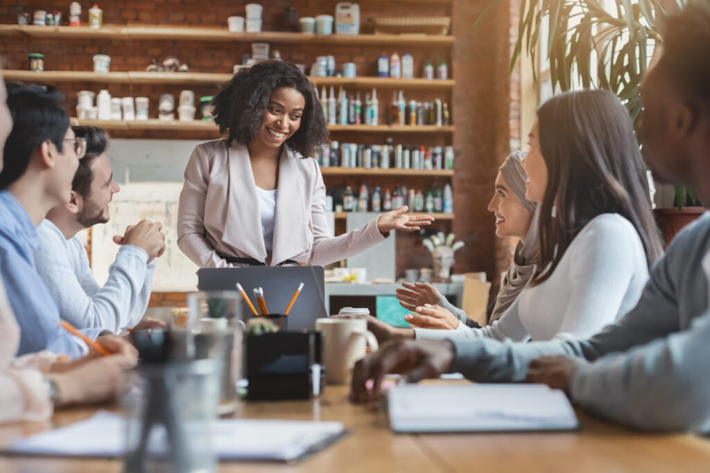 A confident team leader guiding a collaborative discussion, representing growth opportunities in sales and marketing jobs.